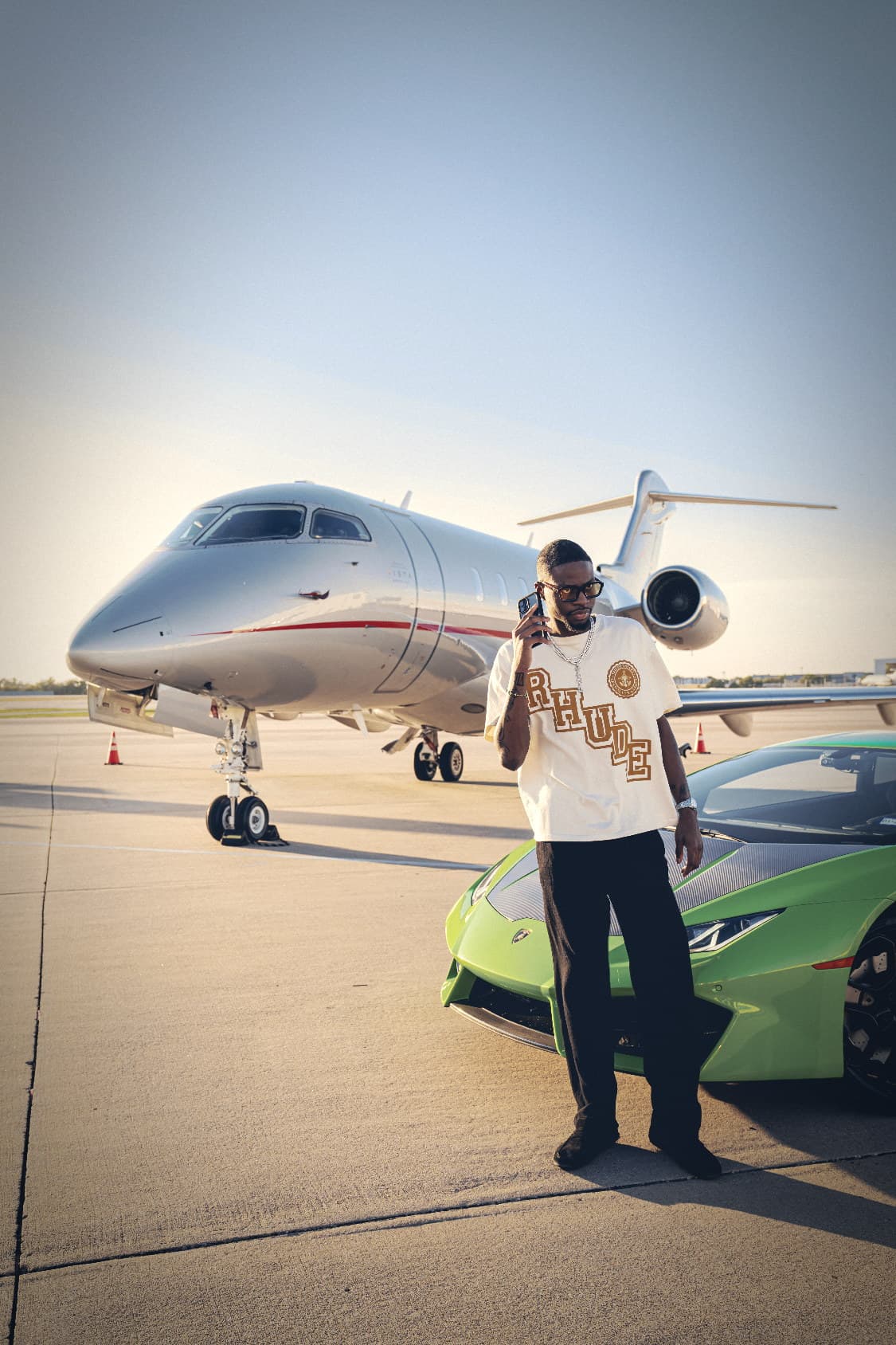Tito Durojaye on the tarmac at golden hour, jet behind, Lamborghini beside